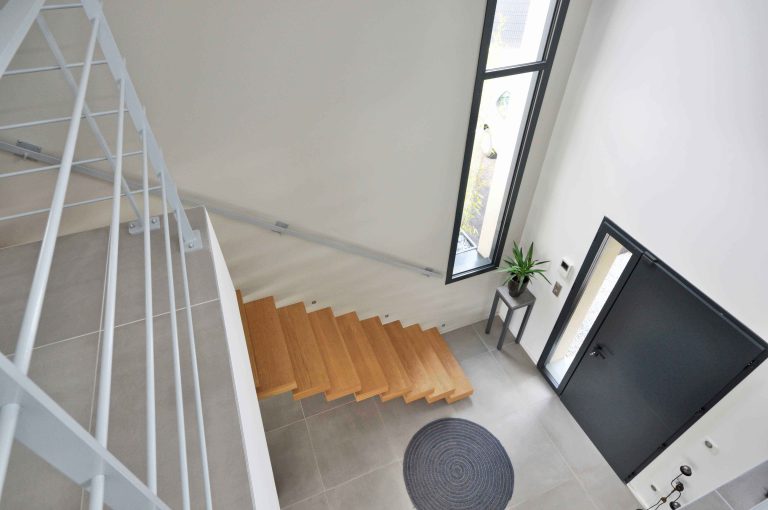 Aménagement de maison neuve de 170m² au nord-ouest de Lyon ; vue de l'escalier et de l'entrée depuis l'étage - PK intérieur, architecte d'intérieur
